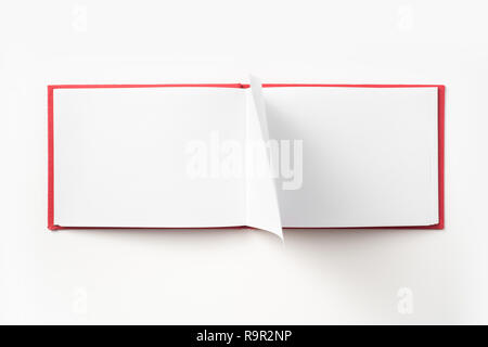 Concept design - Vue de dessus couverture cartonnée rouge portable avec open & curl flip page laminées isolé sur fond de immersive Banque D'Images