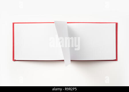 Concept design - Vue de dessus couverture cartonnée rouge portable avec open & curl flip page laminées isolé sur fond de immersive Banque D'Images