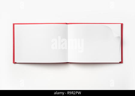 Concept design - Vue de dessus couverture cartonnée rouge portable avec open & curl flip page laminées isolé sur fond de immersive Banque D'Images