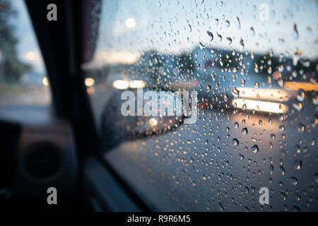 Chute de pluie sur la fenêtre avec la lumière trail Banque D'Images