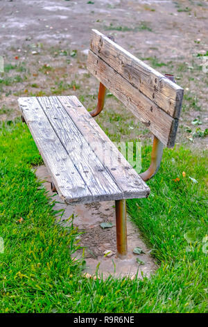Banc en bois peint en blanc sur un terrain herbeux Banque D'Images