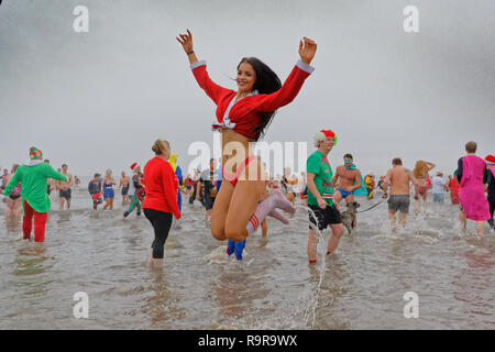 Sur la photo : Une jeune femme en Santa outfit saute dans la mer. Le mardi 25 décembre 2018 Re : des centaines de personnes prennent part à cette année, l'Porthcawl Christm Banque D'Images