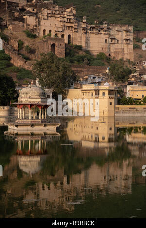 Bundi Palace et Taragarh Fort sur la colline derrière Nawal Sagar Lake baigné de lumière du soir. Le Rajasthan, Inde du nord-ouest. Banque D'Images