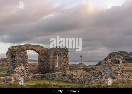 L'église ruinée et Saxon cross à Ynys Llanddwyn sur Anglesey, au nord du Pays de Galles au lever du soleil. Banque D'Images