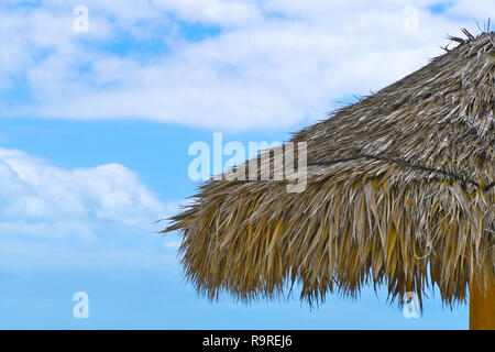 L'herbe de chaume tropical Tiki Hut toiture avec ciel bleu et nuages Banque D'Images