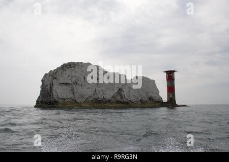 Un grand rocher de craie blanche sur la côte sud de l'Angleterre, avec les aiguilles phare sur l'île de Wight, en silhoutte of mountain range at sunset et vu de la mer Banque D'Images
