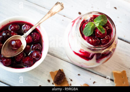 Sweet Cherry cheesecake dans un pot Mason sur table en bois Banque D'Images