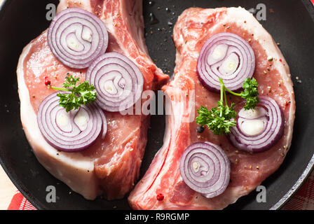 Deux morceaux de matières les côtelettes de porc dans une poêle. Banque D'Images