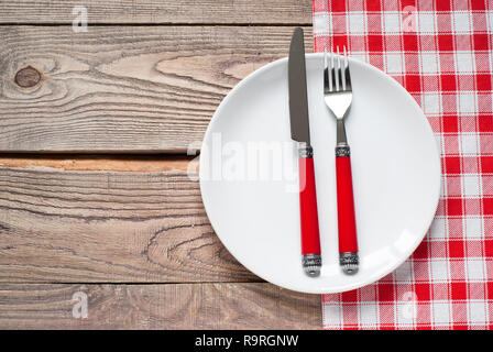 Réglage de la table avec une assiette, des couverts et une serviette en rouge et blanc. Vue du dessus avec copie espace Banque D'Images