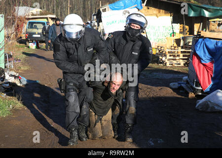 Hambach, Allemagne. 28 Dec, 2018. Les policiers prendre un homme à l'écart dans la soi-disant pré camp. Après plusieurs incidents à la forêt de Hambach, la police a fouillé la soi-disant pré camp des opposants de lignite sur 28.12.2018. Un porte-parole de la police à Aix-la-Chapelle a dit que la recherche était sur des cocktails Molotov ou coupe-boulons ainsi que pour les moyens d'assembler des dispositifs incendiaires. (Dpa 'Razzia à la forêt de Hambach après les incidents de Noël' du 28.12.2018) Crédit : David Young/dpa/Alamy Live News Banque D'Images