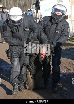 Hambach, Allemagne. 28 Dec, 2018. Les policiers prendre un homme à l'écart dans la soi-disant pré camp. Après plusieurs incidents à la forêt de Hambach, la police a fouillé la soi-disant pré camp des opposants de lignite sur 28.12.2018. Un porte-parole de la police à Aix-la-Chapelle a dit que la recherche était sur des cocktails Molotov ou coupe-boulons ainsi que pour les moyens d'assembler des dispositifs incendiaires. (Dpa 'Razzia à la forêt de Hambach après les incidents de Noël' du 28.12.2018) Crédit : David Young/dpa/Alamy Live News Banque D'Images