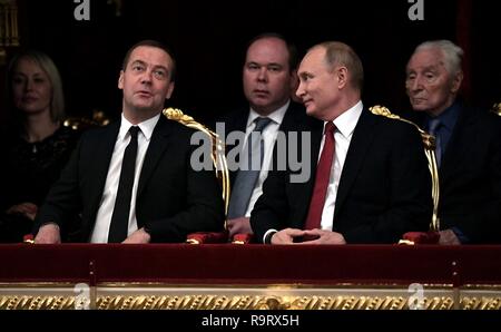 Le président russe Vladimir Poutine, à droite, discute avec le Premier ministre Dmitri Medvedev, gauche, comme chef d'état-major Anton Vaino regarde pendant un concert de Casse-Noisette à l'assemblée annuelle de l'année gala au Théâtre Bolchoï, 27 décembre 2018 à Moscou, Russie. Banque D'Images