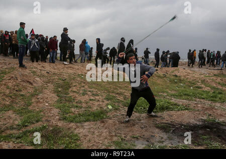 (181229) -- BEIJING, le 29 décembre 2018 (Xinhua) -- un manifestant palestinien lance des pierres sur des soldats israéliens lors d'affrontements à la frontière Gaza-Israel, est de la ville de Gaza, le 28 décembre 2018. Au moins six manifestants palestiniens ont été blessés vendredi après-midi par des tirs de soldats israéliens au cours des affrontements dans l'est de la bande de Gaza, près de la frontière avec Israël, a déclaré que les infirmiers. (XINHUA Xinhua) PHOTOS DE LA JOURNÉE Banque D'Images