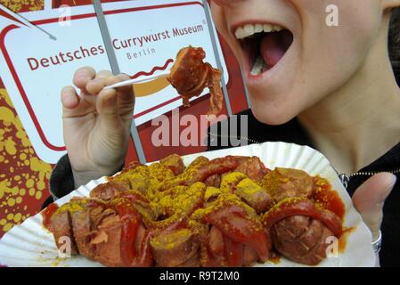 Berlin, Allemagne. 18 Mar, 2009. Une jeune femme dans un bon cœur morsures saucisse au curry en face de l'avenir allemand Currywurst Museum de Berlin. (Dpa "Tout a une fin : Berlin's Currywurst Museum est fermé' à partir de 29.12.2018) Crédit : Tim Brakemeier/dpa/Alamy Live News Banque D'Images