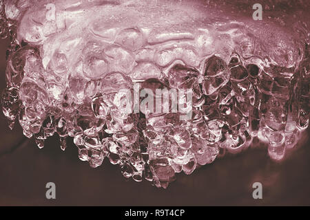 Le ruisseau d'hiver avec les glaçons au-dessus. flux gel Détail de l'omble congelé - petite chute d'eau laiteuse et glaçons en pierre Banque D'Images