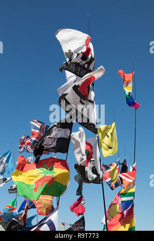 Hollowell, Northamptonshire, Angleterre. Drapeaux et fanions colorés, attachés à des poteaux, minces sont palpitations dans le vent sous un ciel bleu clair. Banque D'Images