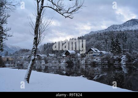 L'agréable et pittoresque de Bad Goisern, Hallstatt, Autriche. Petites maisons couvertes de neige par la rivière, montagnes enneigées à l'arrière-plan. Banque D'Images