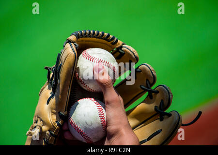 Balles de baseball joueur tenant dans la main et mitt à hauteur Banque D'Images