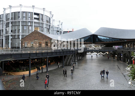 Les détenteurs de gaz immeuble moderne et les gens qui font du shopping dans Coal Drops Yard réaménagement et zone commerciale décembre KINGS Cross London UK KATHY DEWITT Banque D'Images