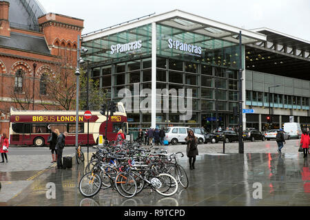 Vue sur la rue avec des vélos garés, un grand bus touristique, des taxis devant la gare de St Pancras signe jour de pluie à Kings Cross Londres UK KATHY DEWITT Banque D'Images