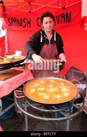 Une femme chef de la préparation de la paella aux crevettes cuisson plat de riz à l'extérieur à l'espagnol Caravan street food Brick Lane East End à Londres E1 UK KATHY DEWITT Banque D'Images