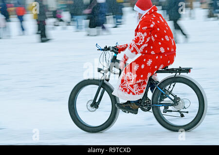 Randonnées cyclistes sur la route.Il porte des vêtements du Père Noël. Banque D'Images