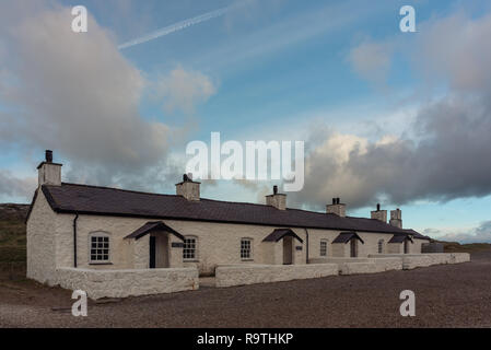 Le pilote's Cottages and cross à Ynys Llanddwyn sur Anglesey, au nord du Pays de Galles au lever du soleil. Banque D'Images