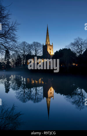 L'église Holy Trinity se reflétant dans la rivière Avon à la tombée de la veille de Noël. Stratford Upon Avon, Warwickshire, en Angleterre. Silhouette Banque D'Images