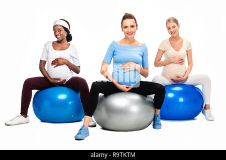 Trois femmes enceintes assis sur des boules de forme physique isolé sur fond blanc Banque D'Images