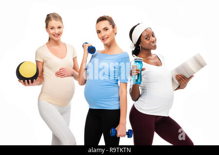 Trois femmes enceintes smiling holding dumbbells et fitness stuff isolated on white Banque D'Images