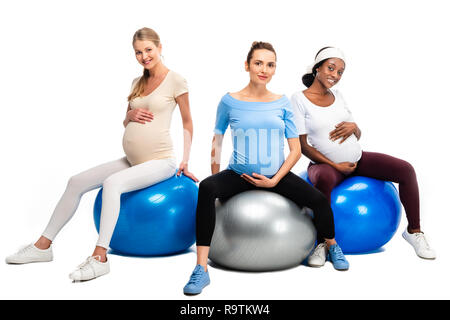 Trois femmes enceintes heureux assis sur des boules de forme physique isolated on white Banque D'Images