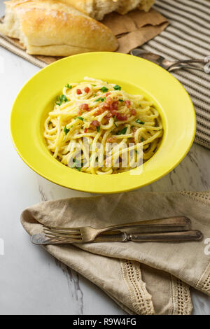 Cuisine italienne crémeuse spaghetti alla carbonara avec du pain croûté et pancetta Banque D'Images
