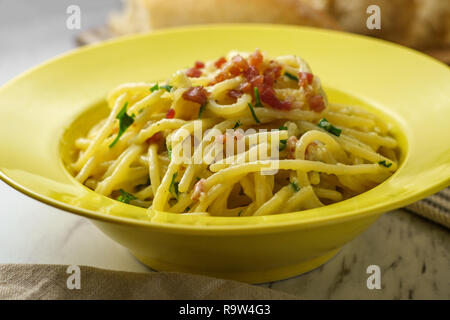 Cuisine italienne crémeuse spaghetti alla carbonara avec du pain croûté et pancetta Banque D'Images