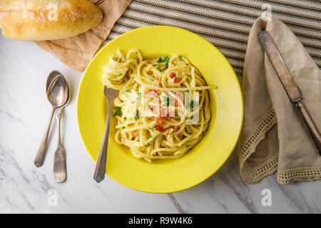 Cuisine italienne crémeuse spaghetti alla carbonara avec du pain croûté et pancetta Banque D'Images