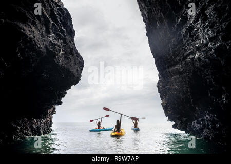 Trois dames des balades en kayak en mer baie entre de gros rochers. Kayak ou canot concept Banque D'Images
