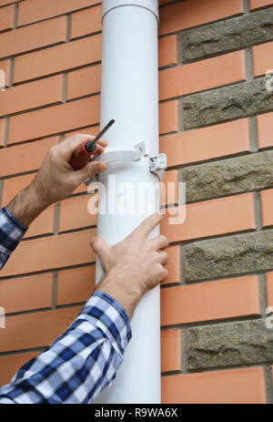 Des gouttières. L'installation de l'entrepreneur gouttière gouttière tuyau de vidange. Banque D'Images