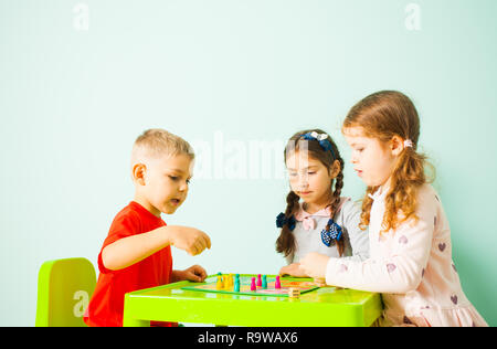 Trois enfants qui jouent à la maison jeu ludo Banque D'Images