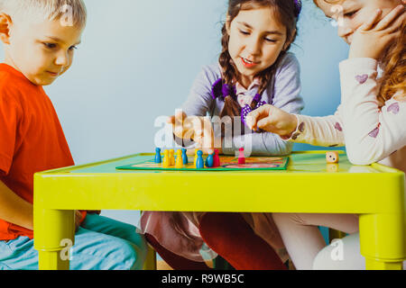 Fermer la vue d'enfants visages autour de table avec jeu de société Banque D'Images