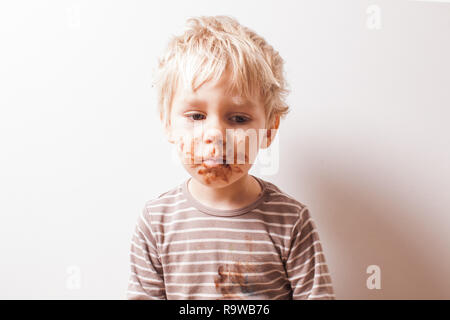 Boy créés et chocolat ont visage sale Banque D'Images