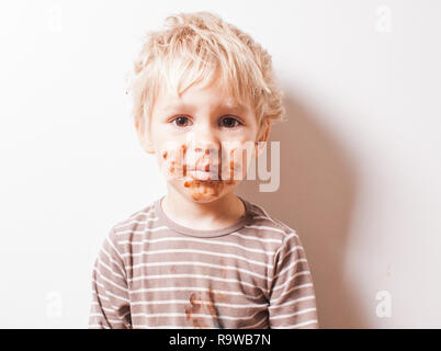 Boy créés et chocolat ont visage sale Banque D'Images