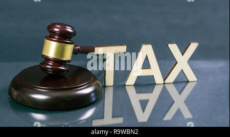 Concept du droit fiscal. Mot taxe avec marteau et de l'argent sur la table. Banque D'Images