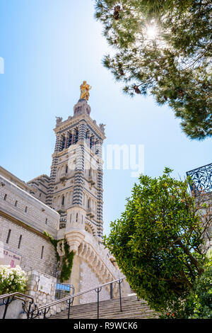 Low angle vue sur le clocher de Notre-Dame de la Garde à Marseille, France, avec la statue dorée de la Vierge à l'enfant en haut. Banque D'Images