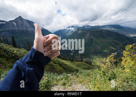 La femelle donne un coup de pouce à la beauté des paysages le long de la route de Sun dans le Glacier National Park du Montana. Concept pour bon travail Banque D'Images