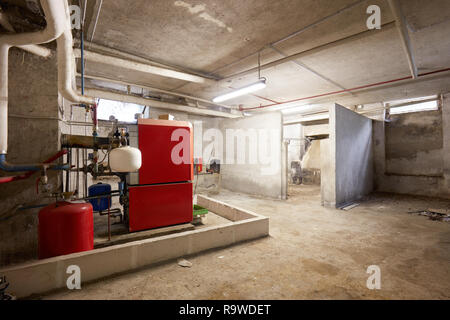 Sous-sol avec chaudière de chauffage rouge et sale dans le vieux house interior Banque D'Images