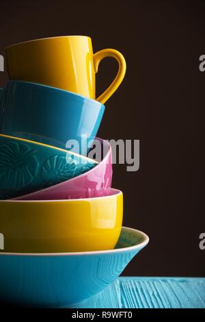 Des tasses et bols en céramique - en bleu, jaune et rose Banque D'Images