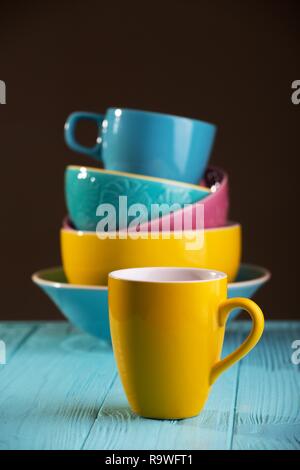 Des tasses et bols en céramique - en bleu, jaune et rose Banque D'Images