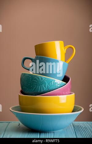 Des tasses et bols en céramique - en bleu, jaune et rose Banque D'Images