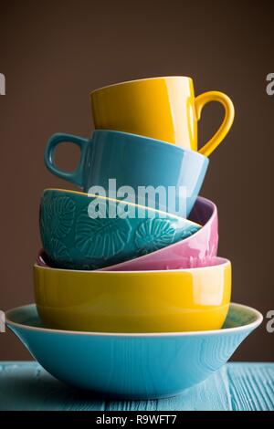 Des tasses et bols en céramique - en bleu, jaune et rose Banque D'Images