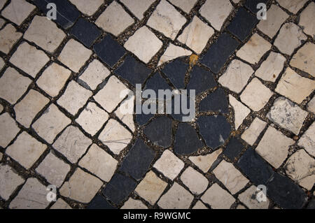 Jouant avec des formes et des motifs différents d'une rue pavée de Lisbonne (Portugal). Croix Noire. Banque D'Images