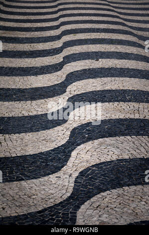 Jouant avec des formes et des motifs différents d'une rue pavée de Lisbonne (Portugal). Le noir et blanc pavées dénudée Banque D'Images